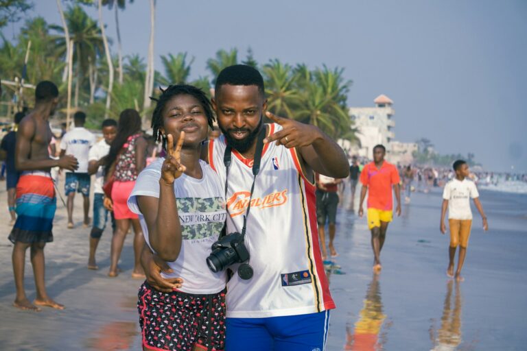 man in white and orange crew neck t-shirt standing beside woman in white t-shirt