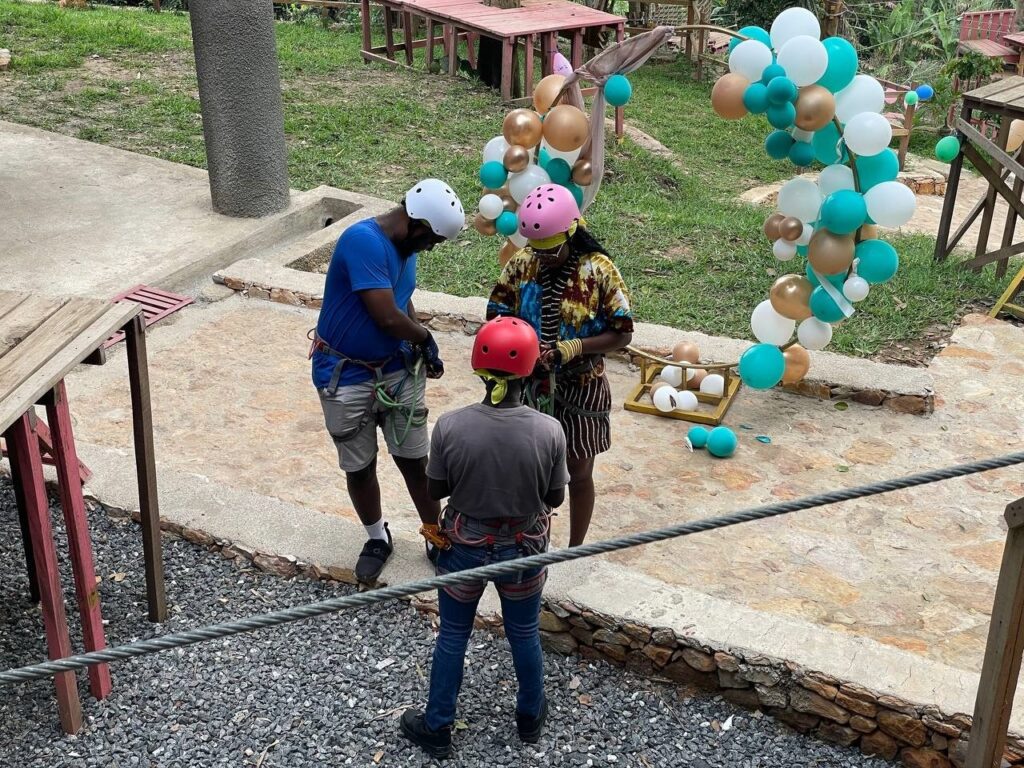 Aerial view of We-Ape Adventure Park nestled in the lush rainforest of Aburi, showcasing zipline platforms and forest trails