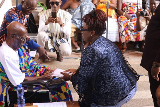 Tourism Minister Dzifa Gomashie presents a gift to Agya Koo Nimo during a courtesy visit at his Kumasi home.